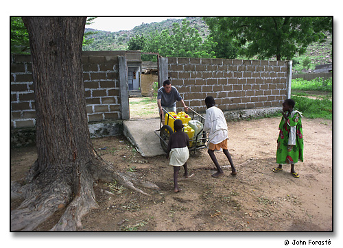 Alex with water jugs, Mora, Cameroon, Africa