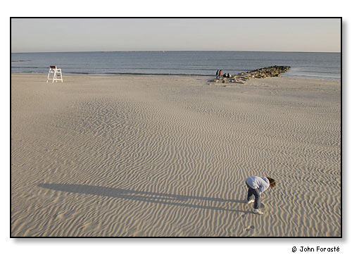 Girl exploring beach late in day. Narragansett, Rhode Island. May 2003.