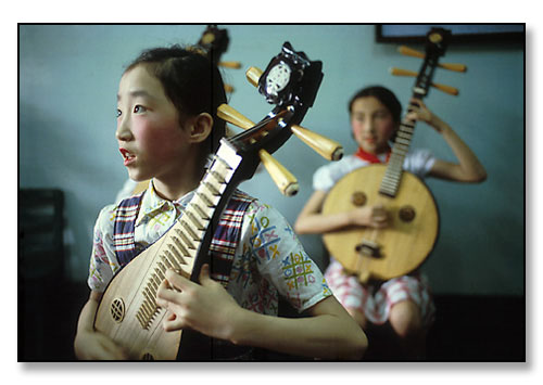 Girls playing traditional chinese instruments. China. July 1979.