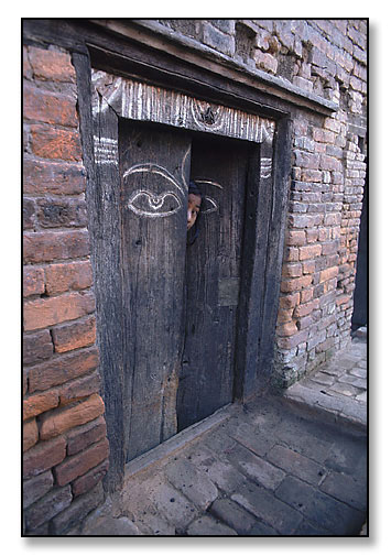Girl in doorway with eye. <br>Calcutta, India. January 1976.